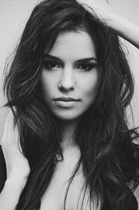 Black and white image of gorgeous brunette looking straight at the camera with long dark hair. Illustrating natural full bodied volume that can be achieved with LUSHIERE CLIP IN HAIR EXTENSIONS 