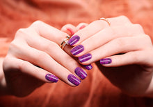 Image of manicured hands wearing nail wraps nail stickers in Purple Shatter design