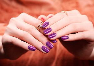 Image of manicured hands wearing nail wraps nail stickers in Purple Shatter design